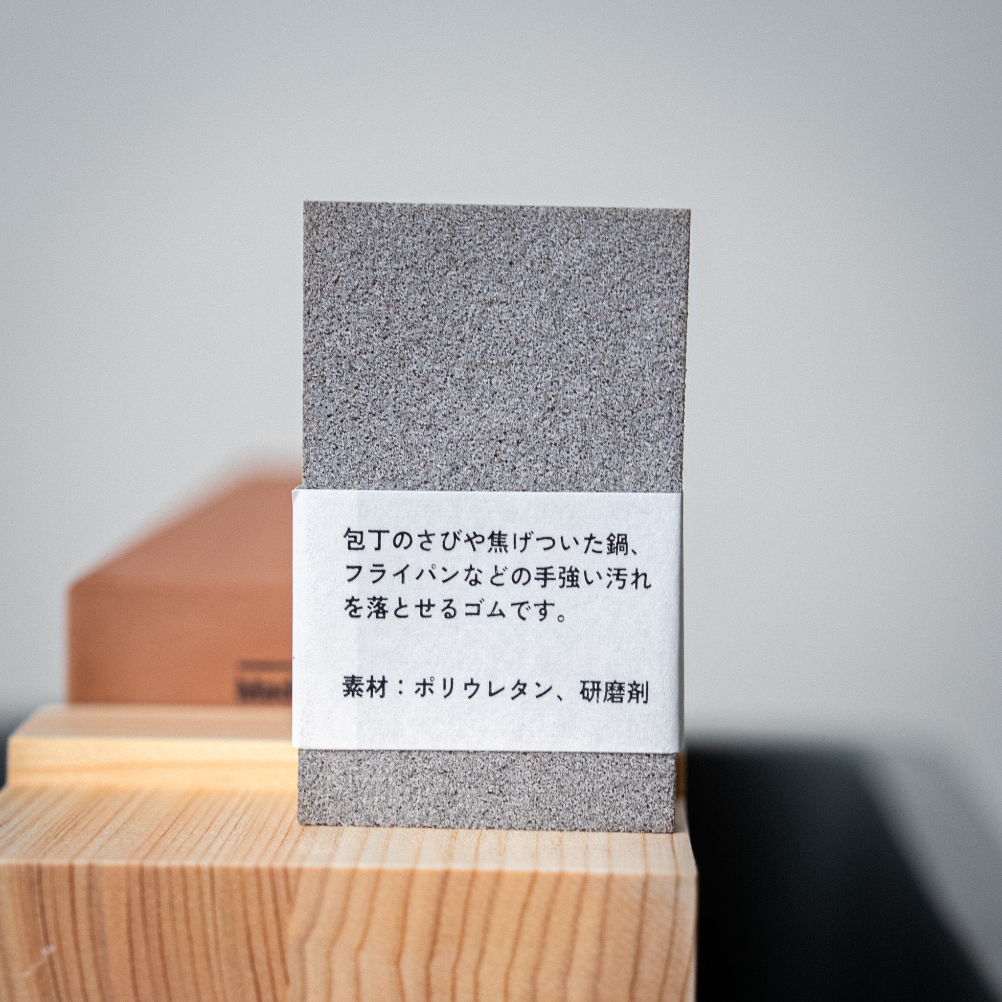 Gomme japonaise pour nettoyage de couteau japonais, posée sur le support bois.


