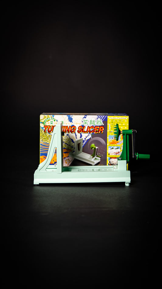 Benriner Turning Slicer japonais photographié de face avec sa boîte — outil de coupe manuel.