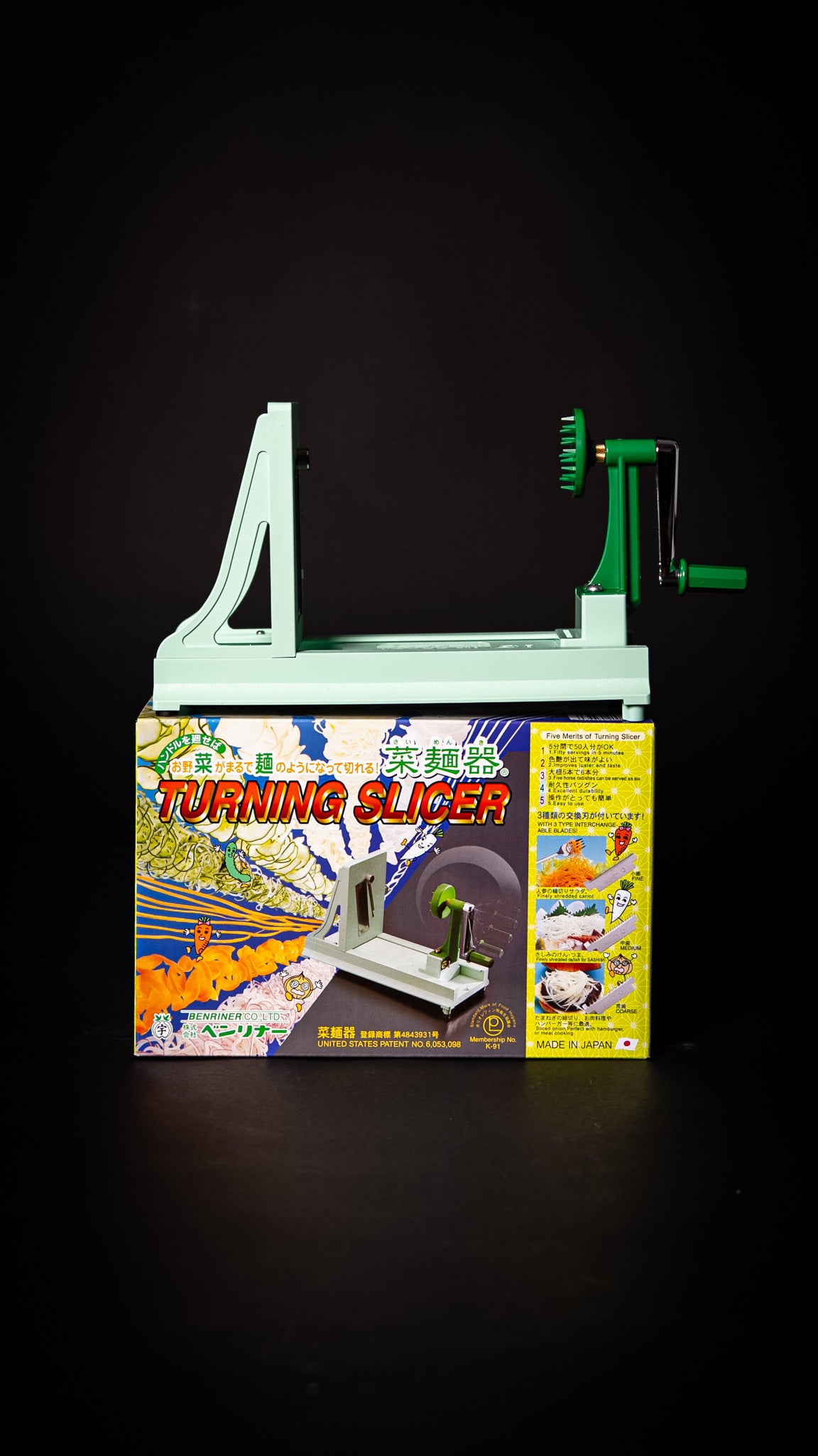 Vue latérale du Benriner Turning Slicer japonais posé sur sa boîte — mécanisme manuel.