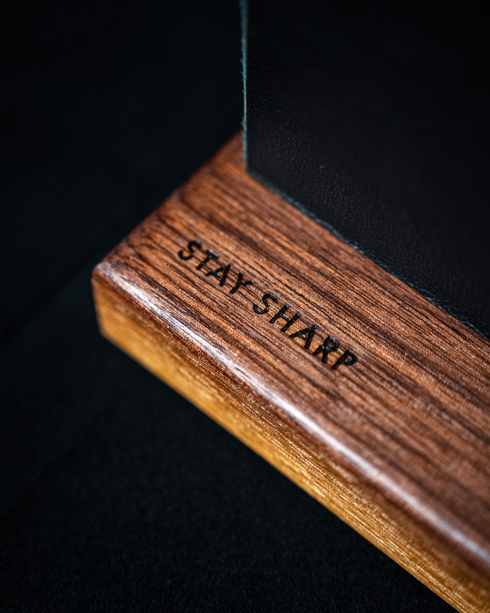 Support magnétique Stay Sharp en bois de noyer rougeâtre, avec lame visible et texture du cuir noir.