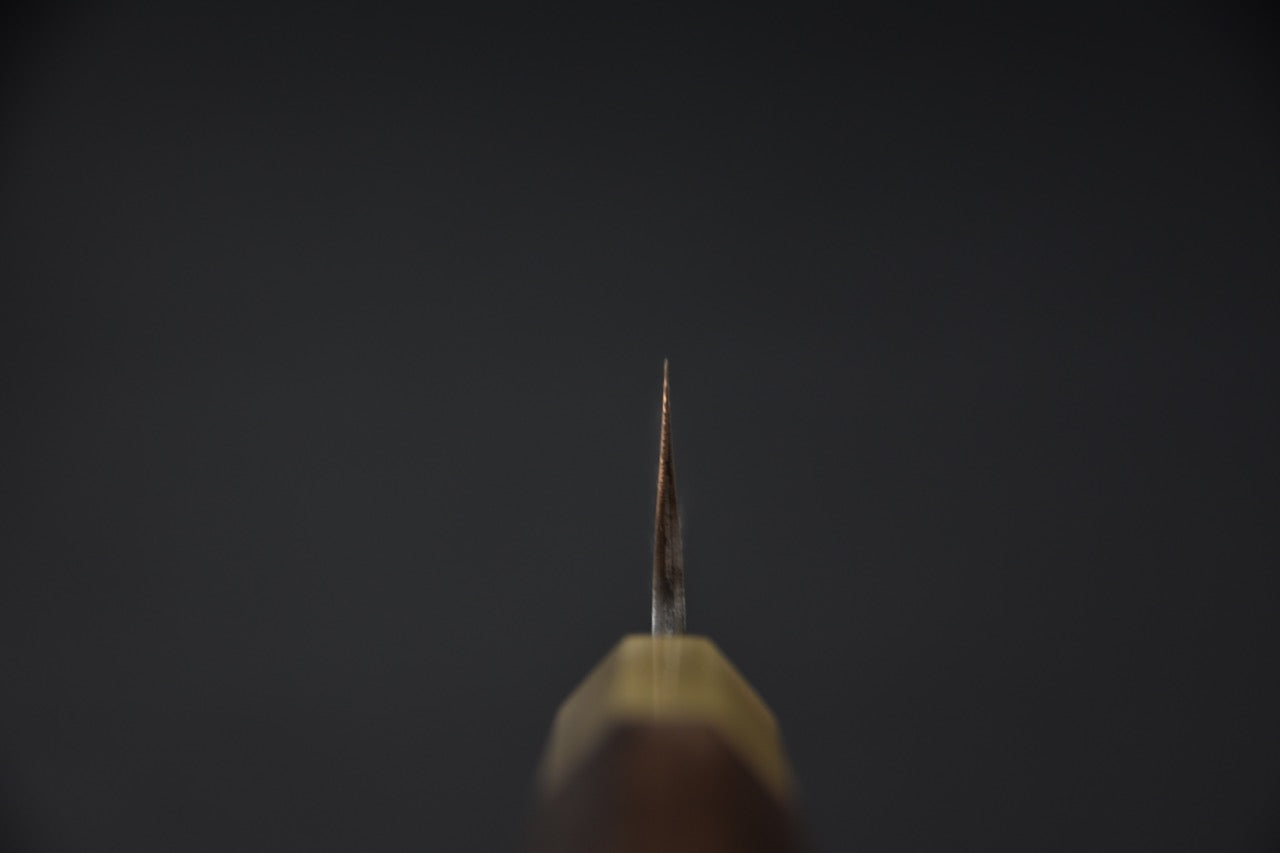 Vue rapprochée du derrière de la lame d'un couteau japonais Petty avec finition martelée distinctive