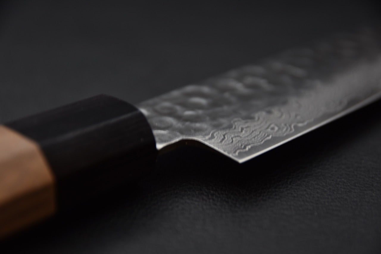 Gros plan sur la lame en acier damas du couteau Sujihiki avec manche en bois