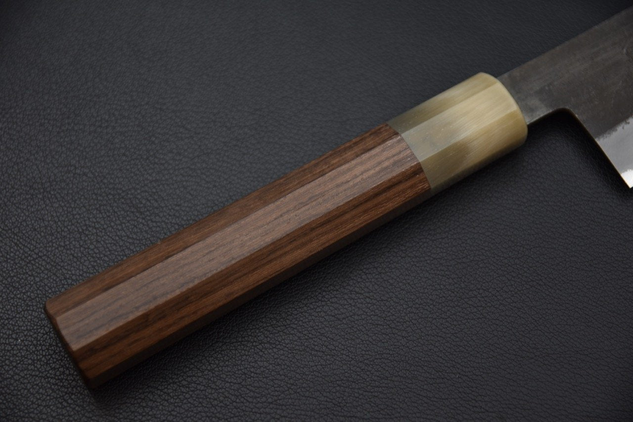 Manche en bois du couteau Gyuto Hinode par Hitohira sur fond noir texturé