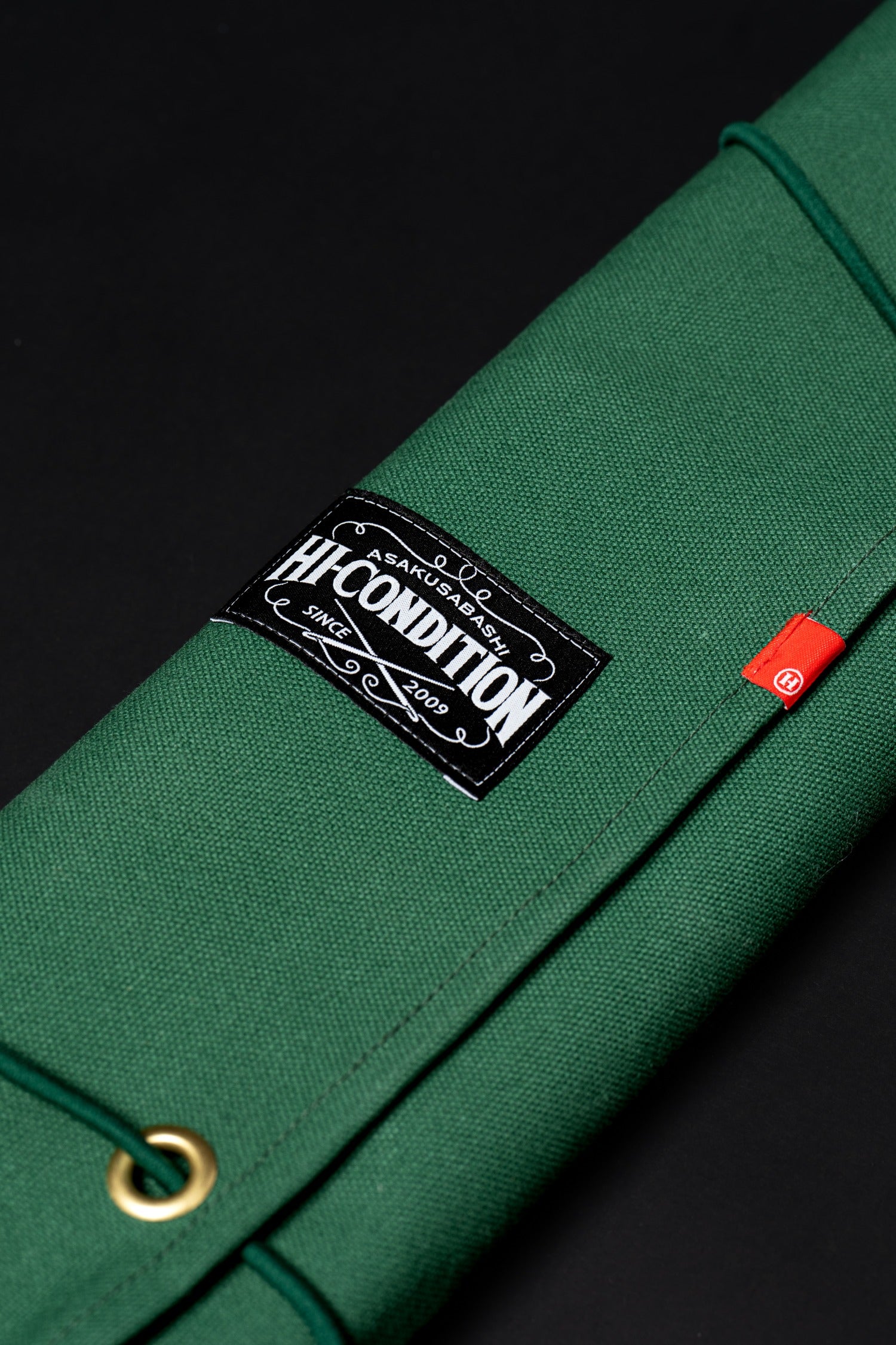 Rouleau HI-CONDITION Mid Green fermé avec deux cordons pour transporter neuf couteaux japonais.