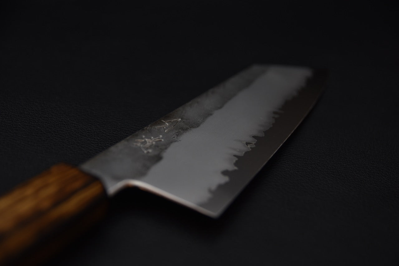 Gros plan sur la lame d’un couteau japonais Bunka montrant la ligne de trempe et le polissage.