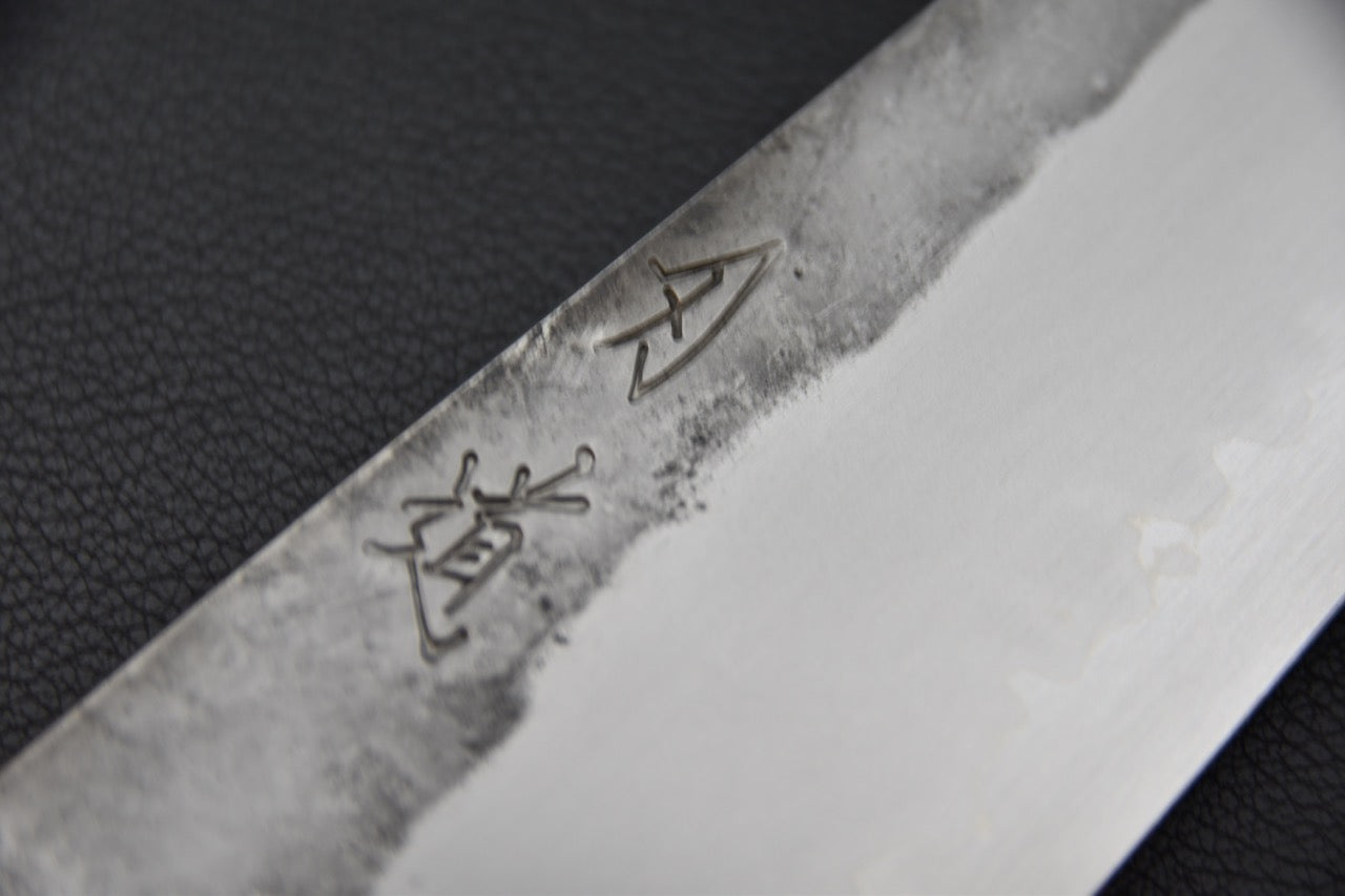 Gravure artisanale sur la lame d’un couteau japonais Bunka Kirisame en acier Shirogami.