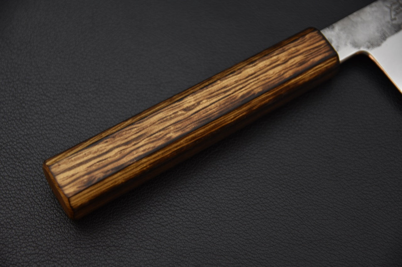 Détail du manche en bois naturel d’un couteau japonais Bunka traditionnel.