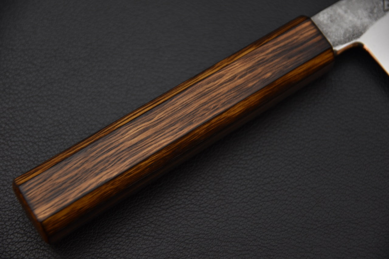 Vue du tranchant fin et acéré d’un couteau japonais Ko-Bunka forgé à la main.