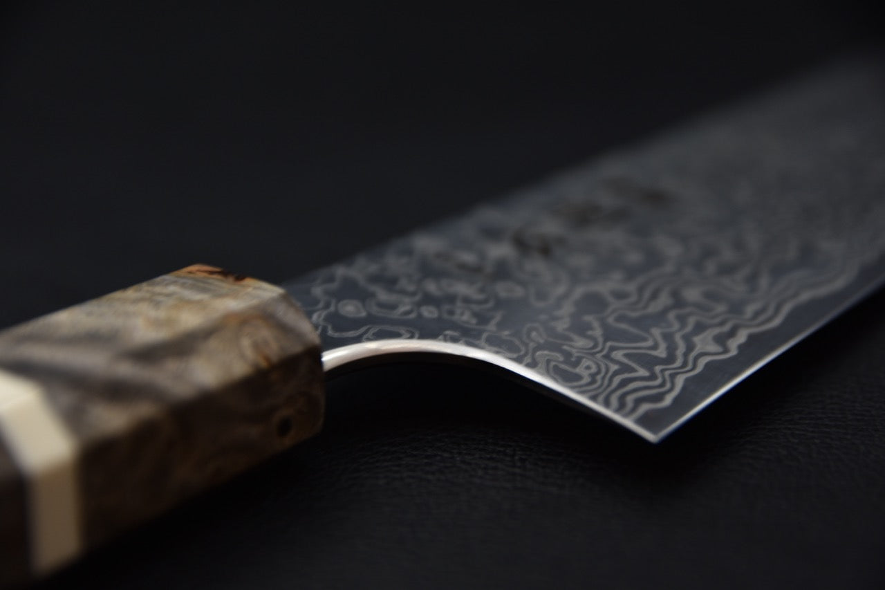 Vue de la tranche et de l’émouture du couteau japonais Santoku Hatsukokoro Ginga 180mm.