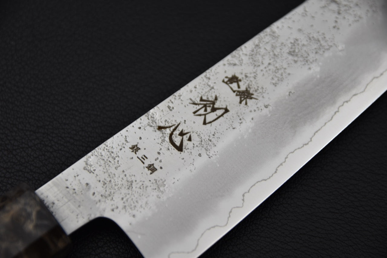 Détail de la lame du couteau japonais Hatsukokoro Ginrei, ligne de trempe visible et kanji gravés.