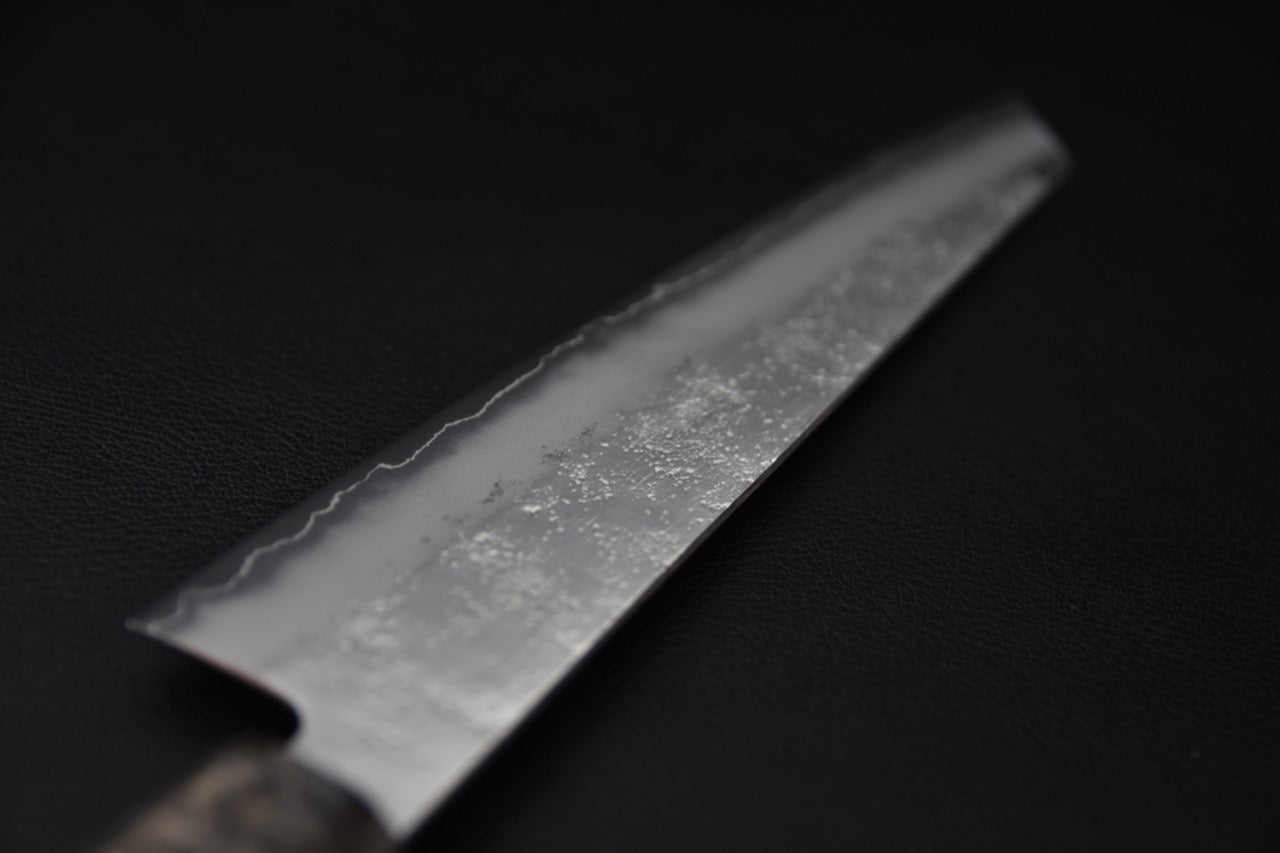 Gros plan sur la finition texturée de la lame en acier Ginsan inox, couteau japonais.