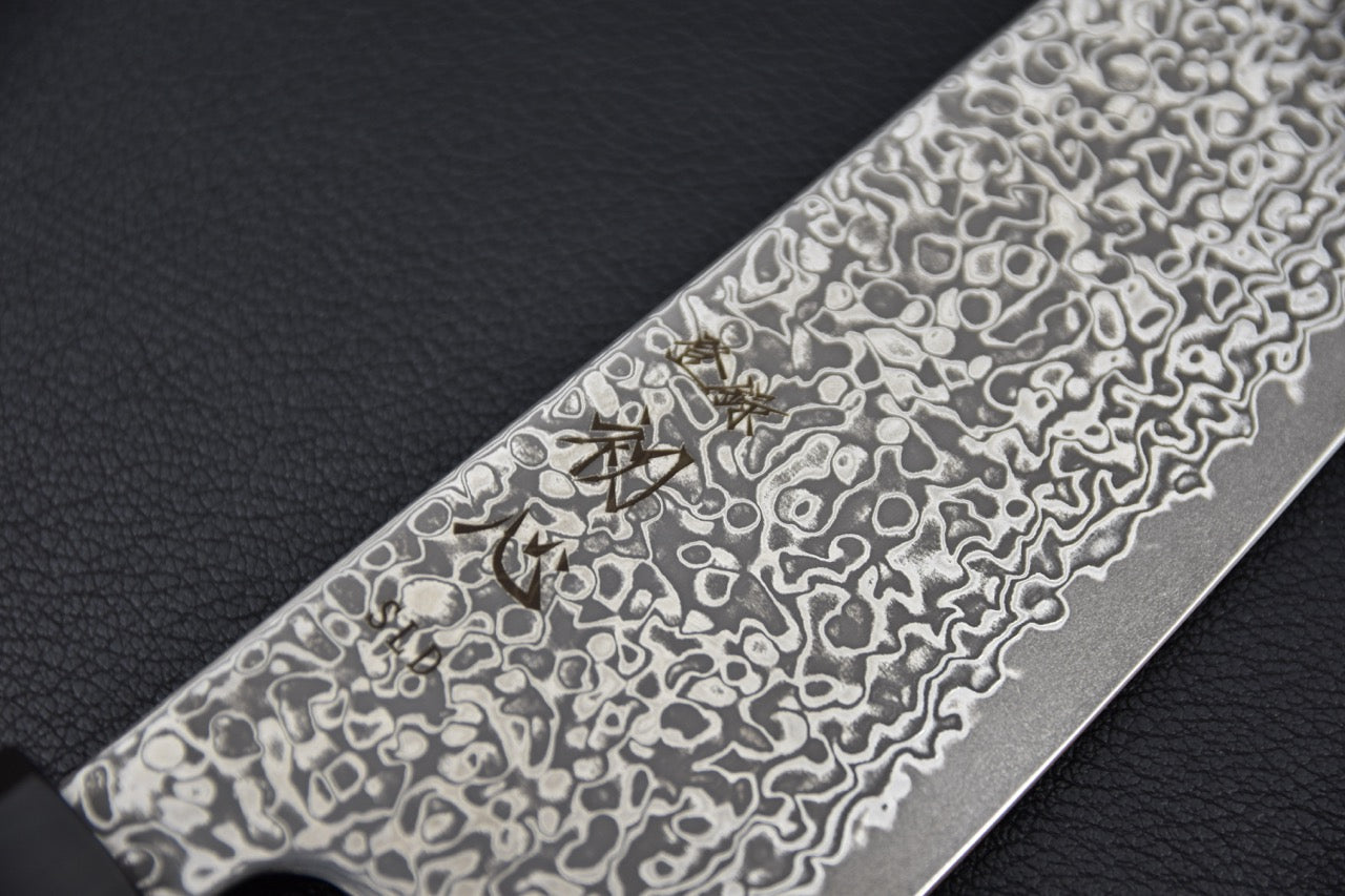 Couteau japonais gyuto 210mm, motif damas et gravure visibles sur la lame.