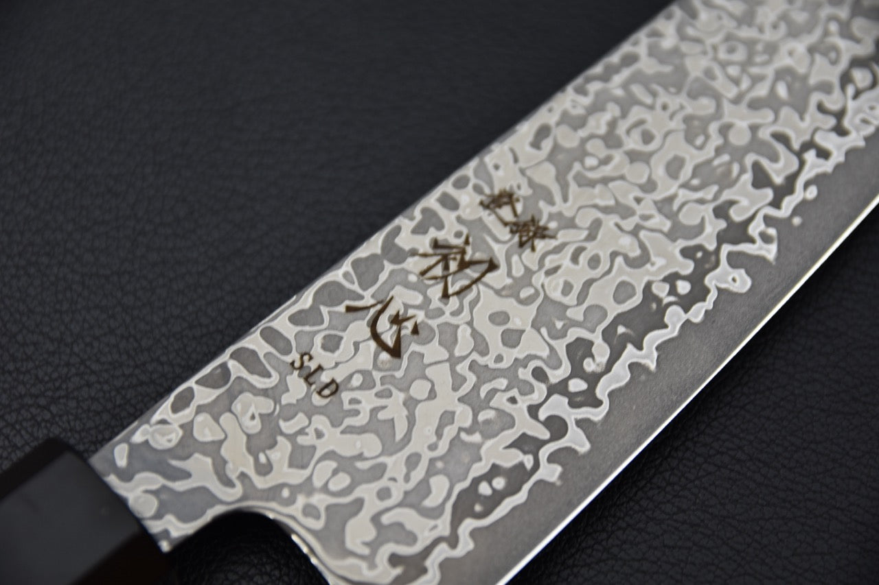 Couteau japonais Gyuto 195 mm, gros plan sur les kanji gravés sur la lame damassée.
