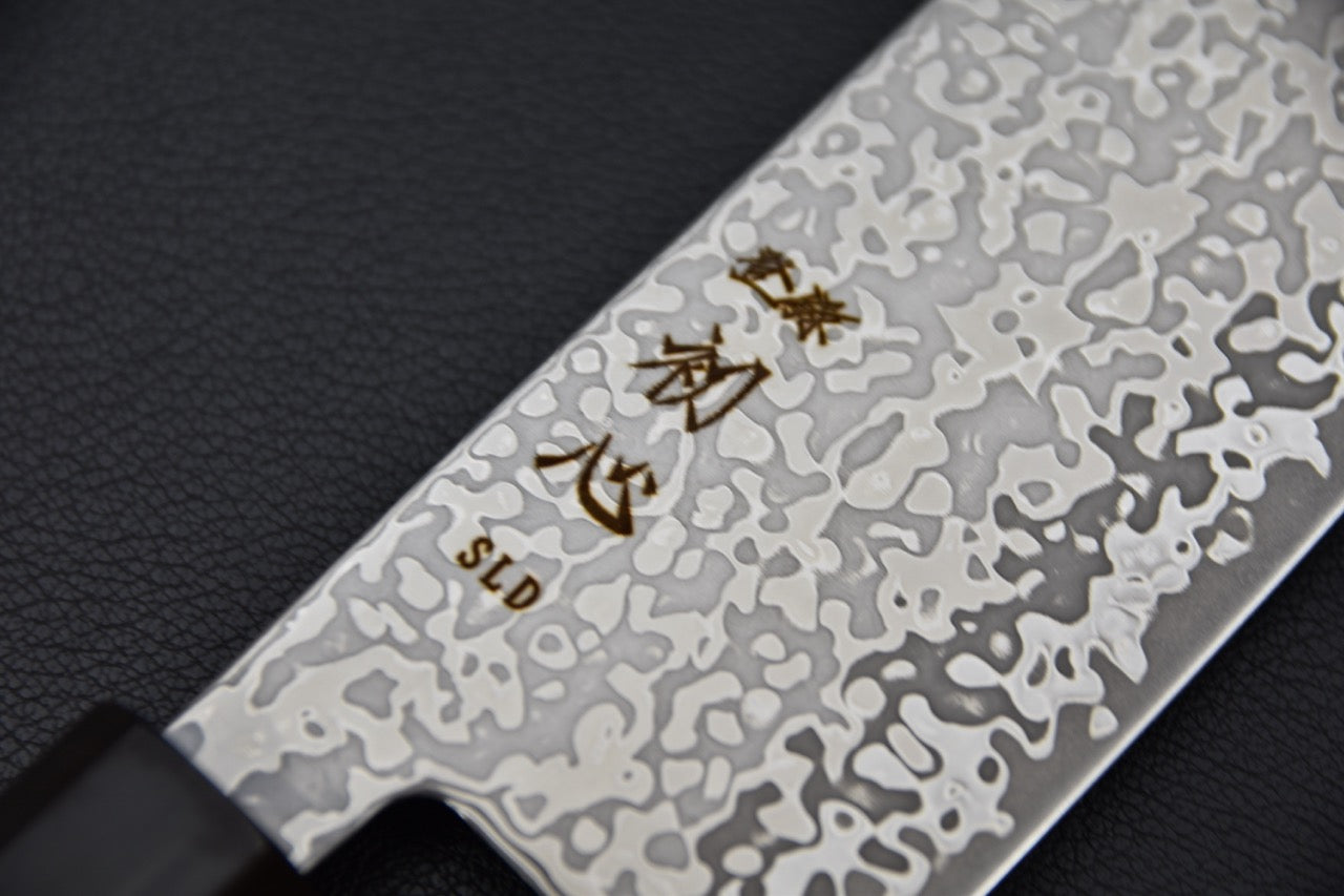 Gros plan sur la gravure et la finition Kurozome de la lame SLD.