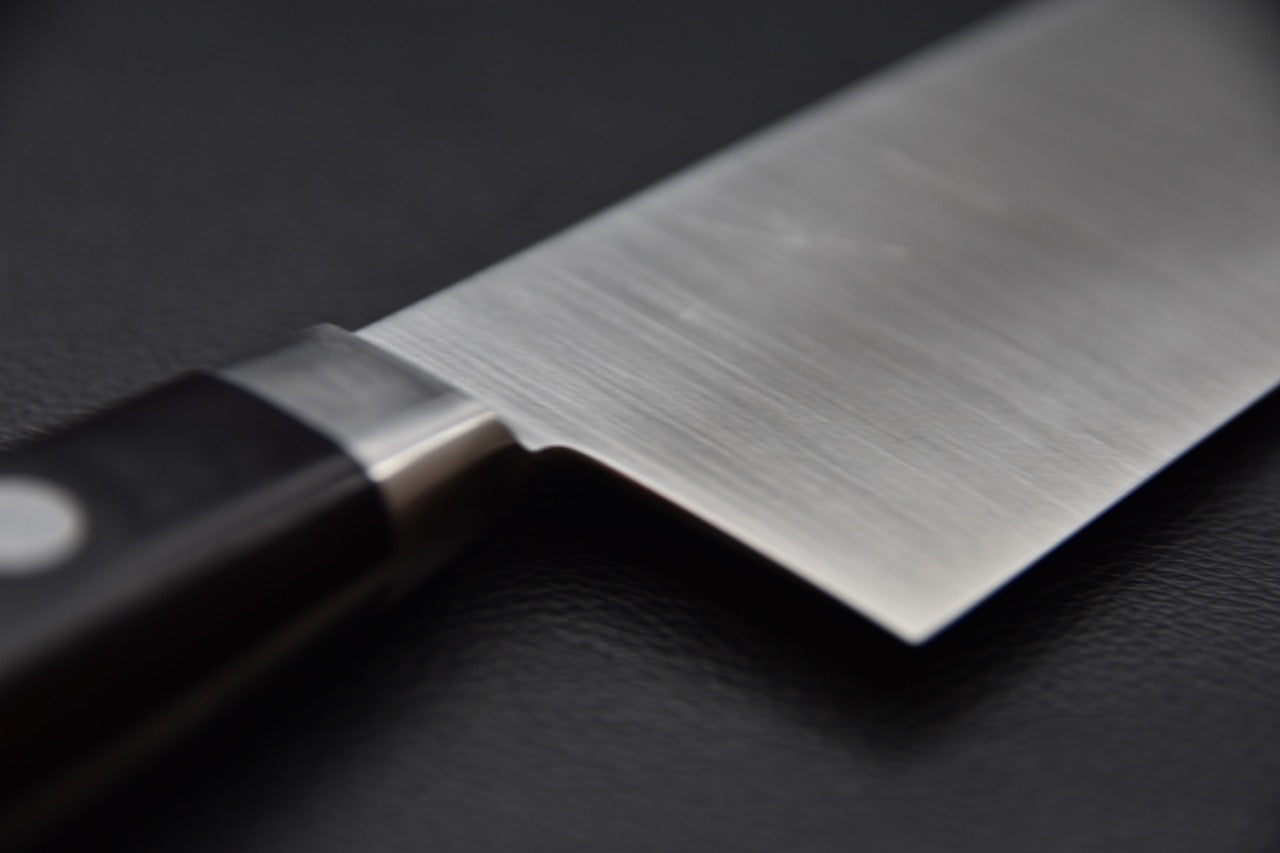 Vue du tranchant ultra-fin d’un couteau japonais Nakiri, aiguisé avec précision artisanale.