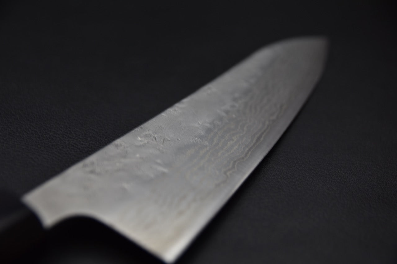 Gros plan sur la lame damassée du Gyuto, mettant en valeur la texture Nashiji et les vagues du motif.