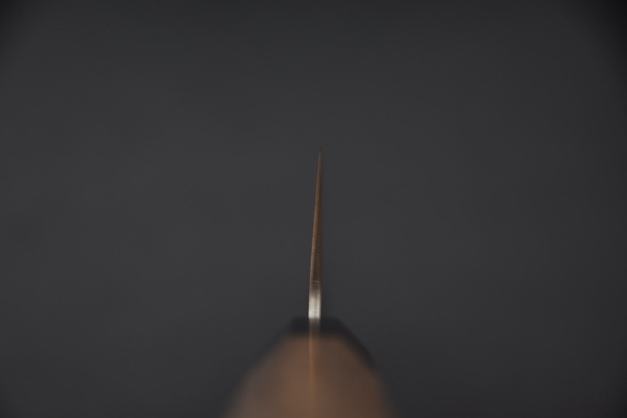 Zoom sur la transition entre la lame et le manche, mettant en valeur la finition précise au niveau du talon.