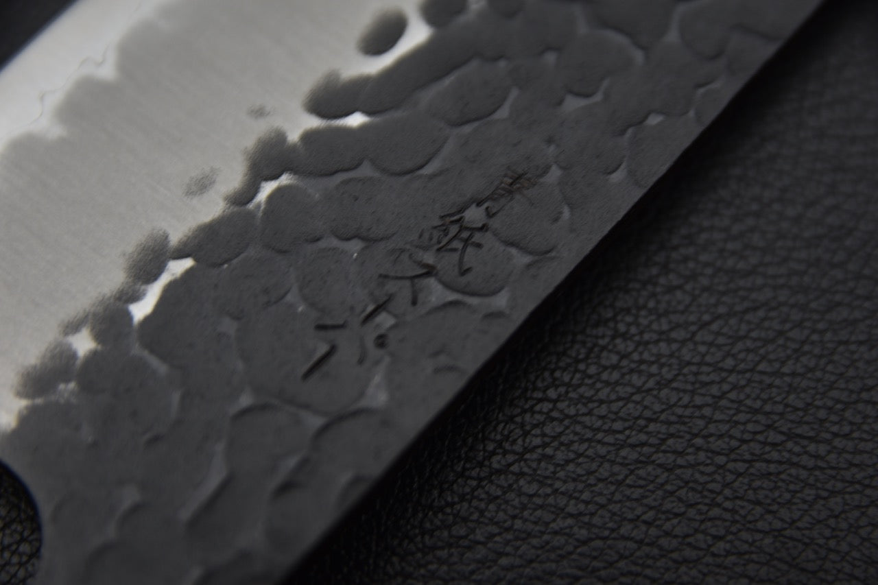 Détail de la gravure kanji sur la surface martelée de la lame