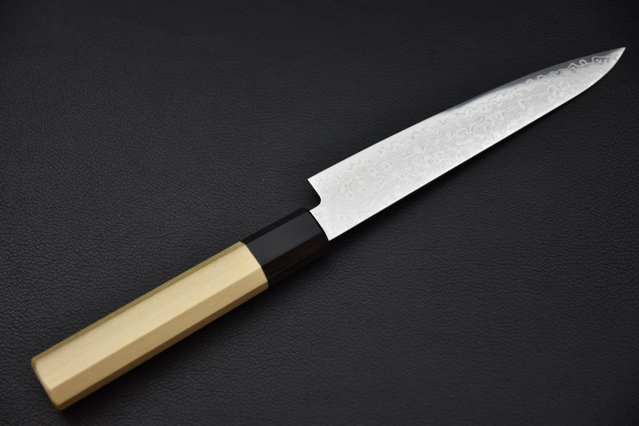 Vue latérale du couteau japonais Hitohira HG Damascus petty montrant la lame brillante et le manche octogonal.