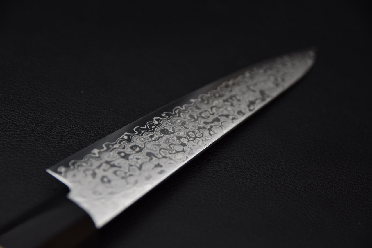 Gros plan sur la lame du couteau japonais Hitohira HG Damascus petty avec motif damas détaillé.