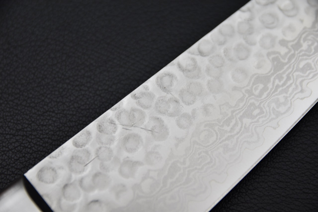 Gros plan sur le motif damas de la lame du couteau japonais gyuto Hitohira HG