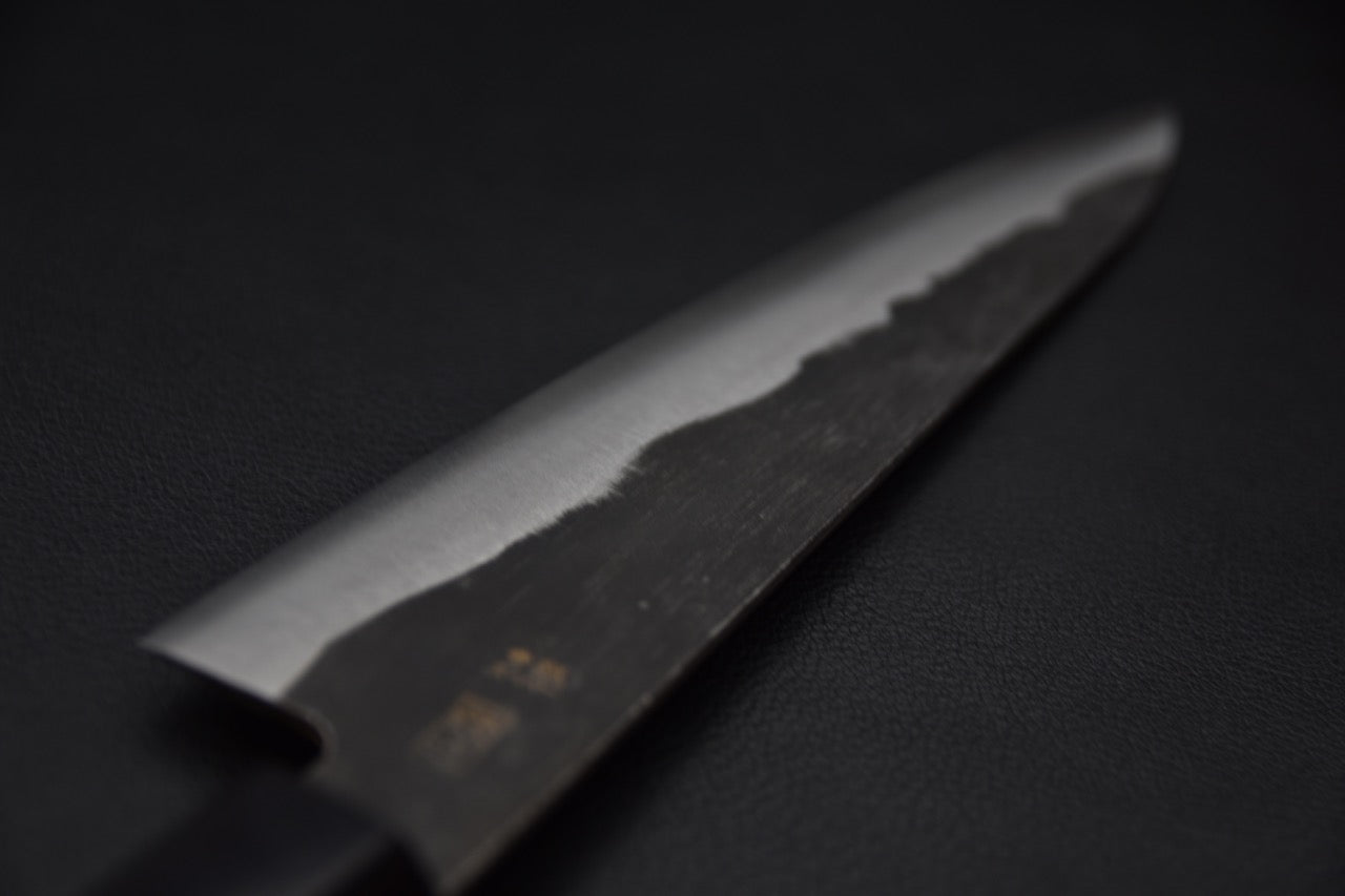 Zoom sur les kanji gravés à la main d’un couteau japonais Gyuto.