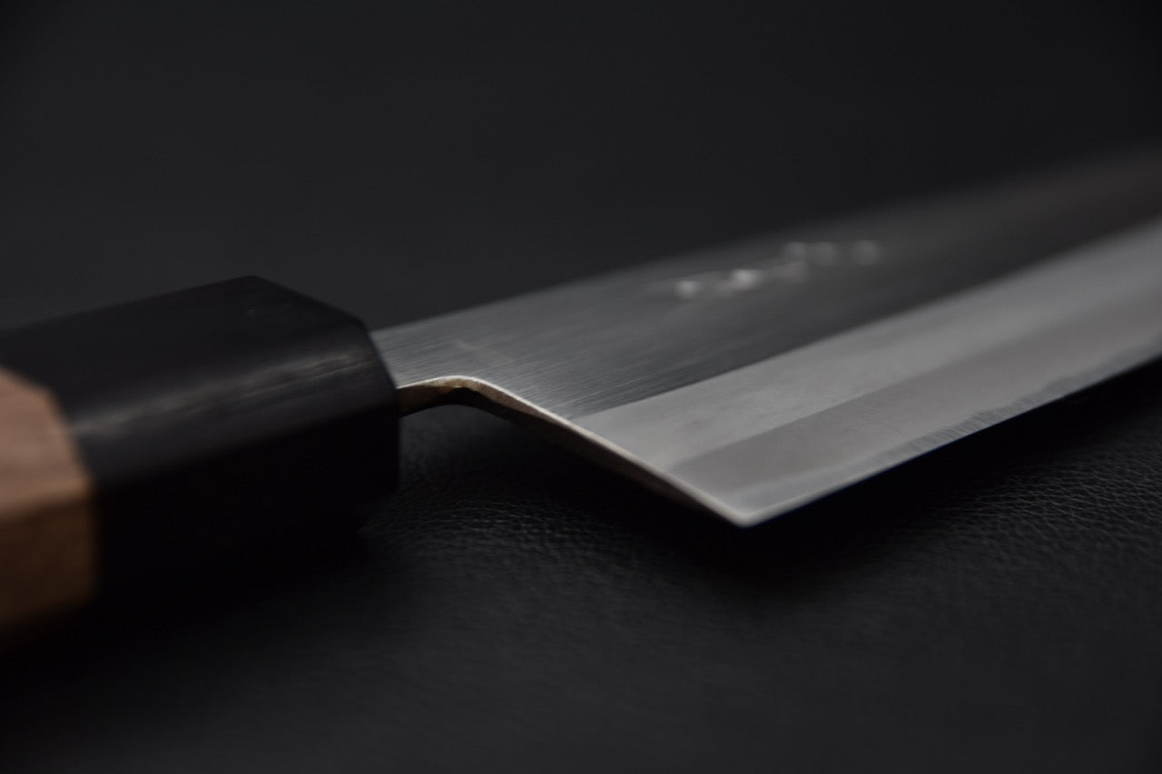 "Vue rapprochée du talon et de la jonction manche-lame du couteau japonais."