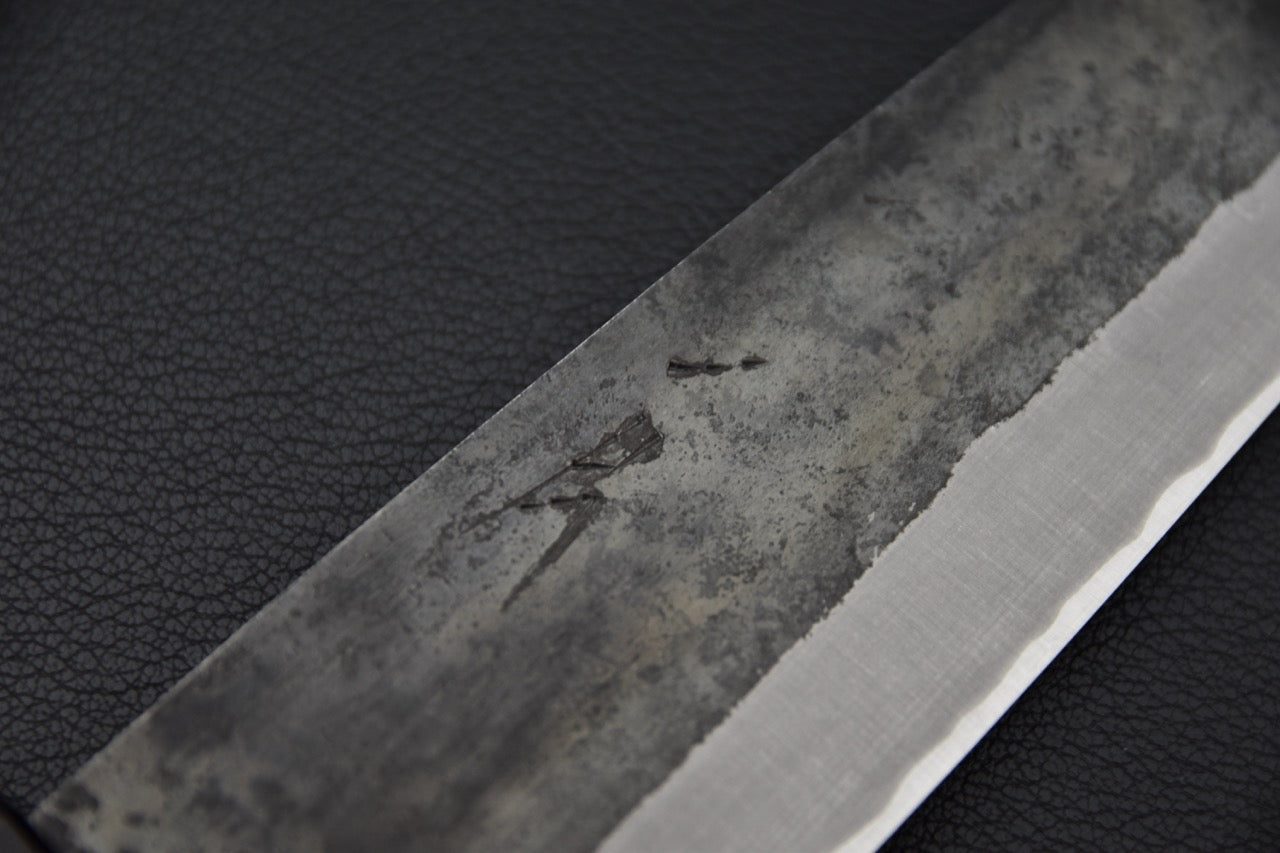 Détail de la lame kurouchi du couteau japonais Hitohira Harima Blue #2, montrant la texture forgée et le tranchant poli.