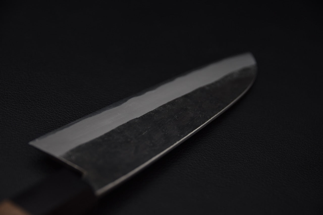 Gros plan sur le tranchant poli du couteau japonais Santoku Hitohira Harima Blue #2 Kurouchi.