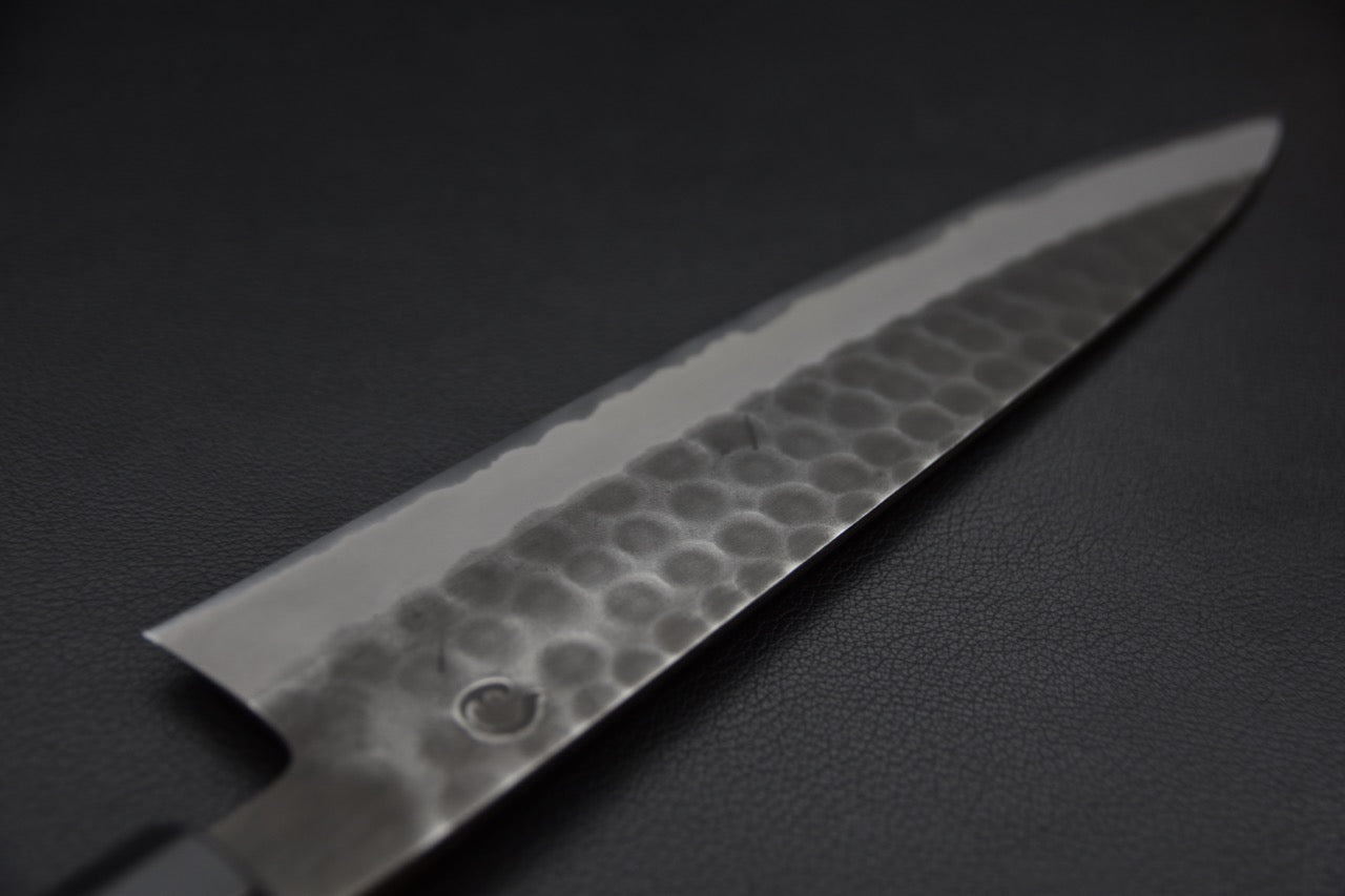 Couteau japonais Gyuto 240mm de Hitohira sur fond noir avec finition martelée Tsuchime.