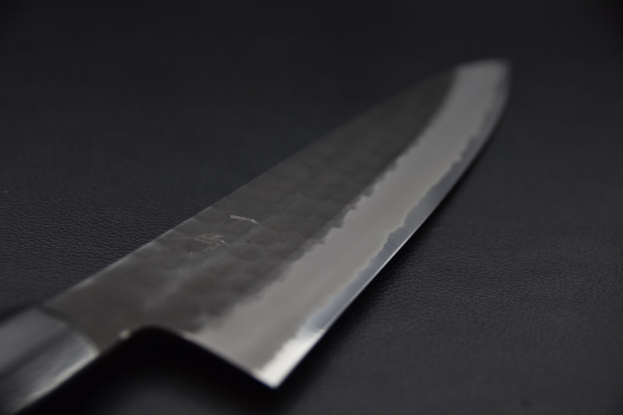 Lame brillante avec détails martelés et finition miroir.