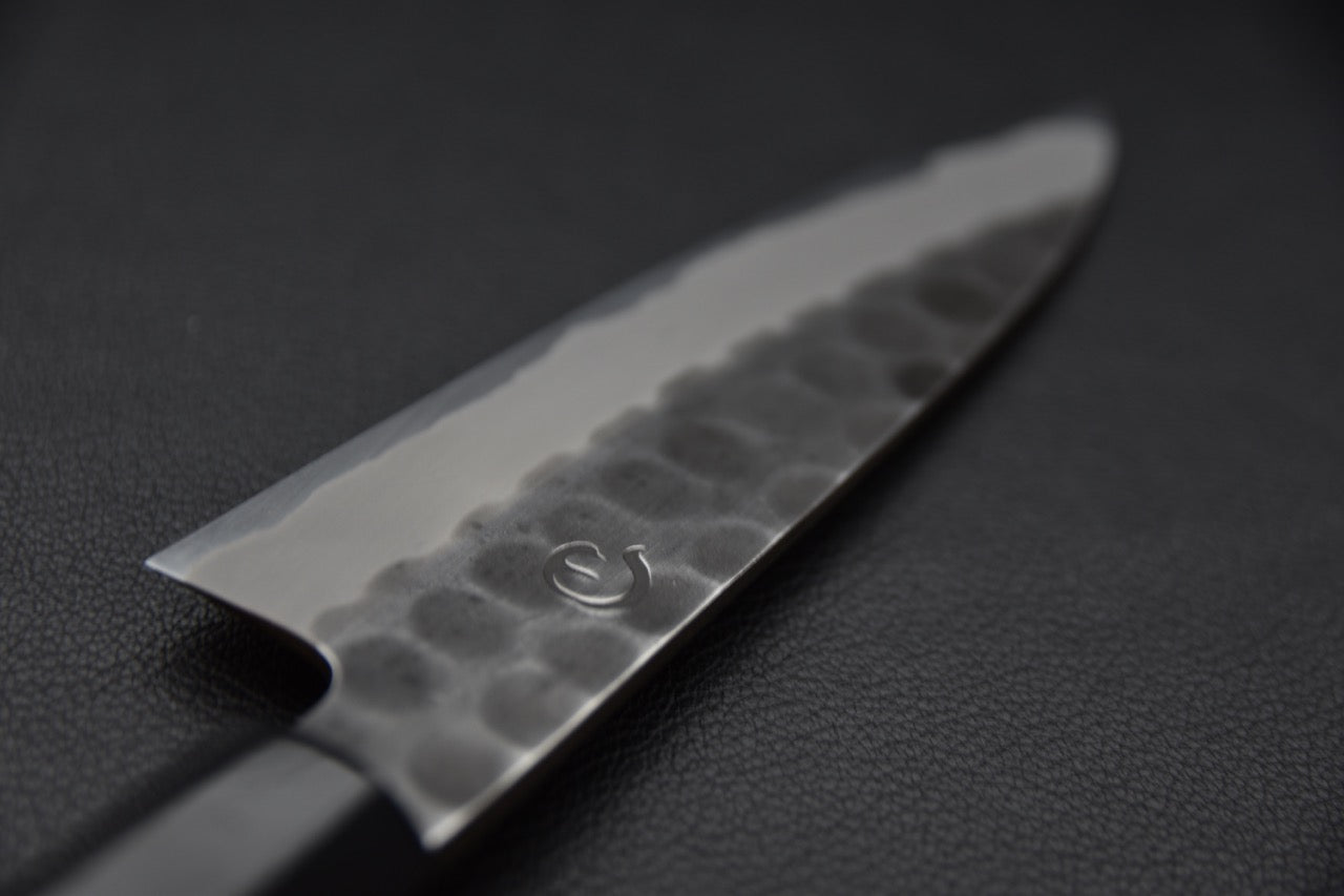 Détail rapproché du logo Hinode gravé sur la lame.