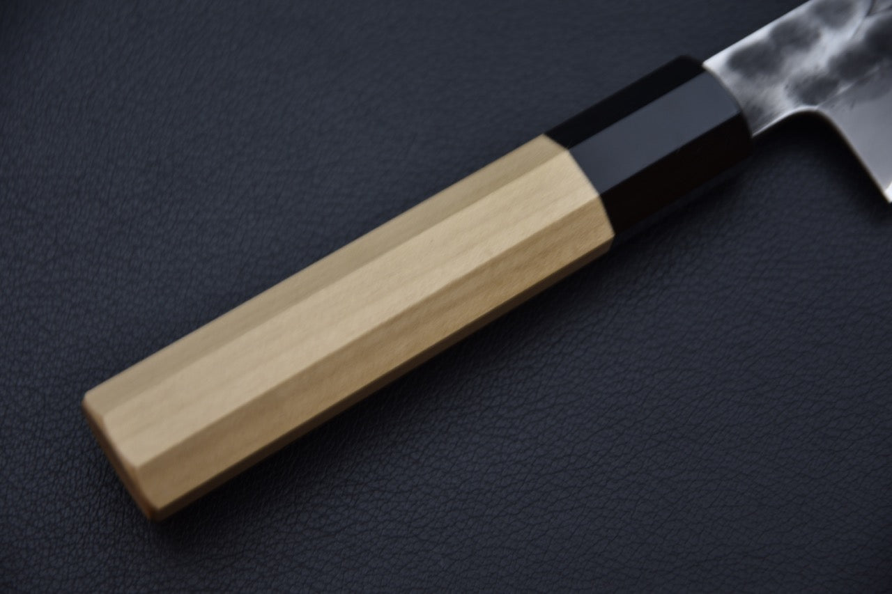 Autre angle du logo Hinode gravé dans la texture martelée.