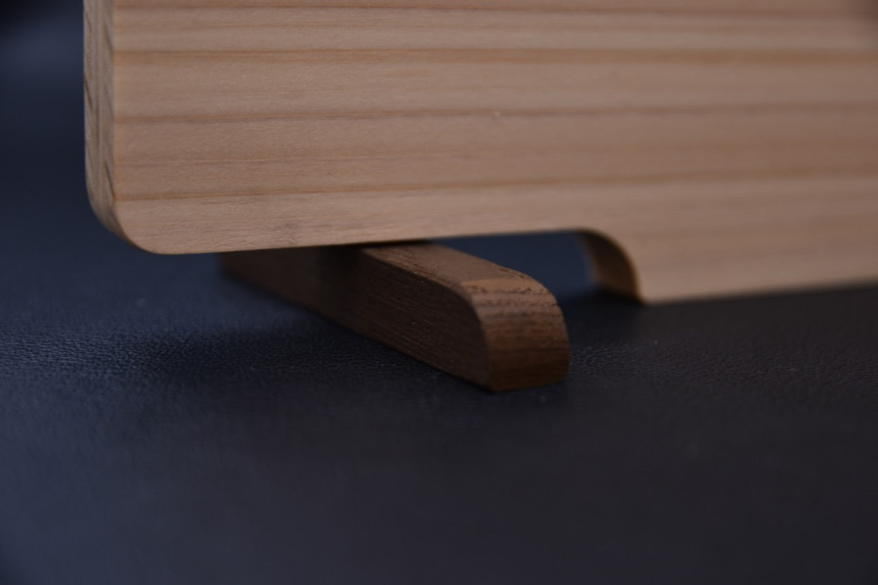 Détail de la base en bois de rose servant de support à la planche à découper japonaise Hitohira.