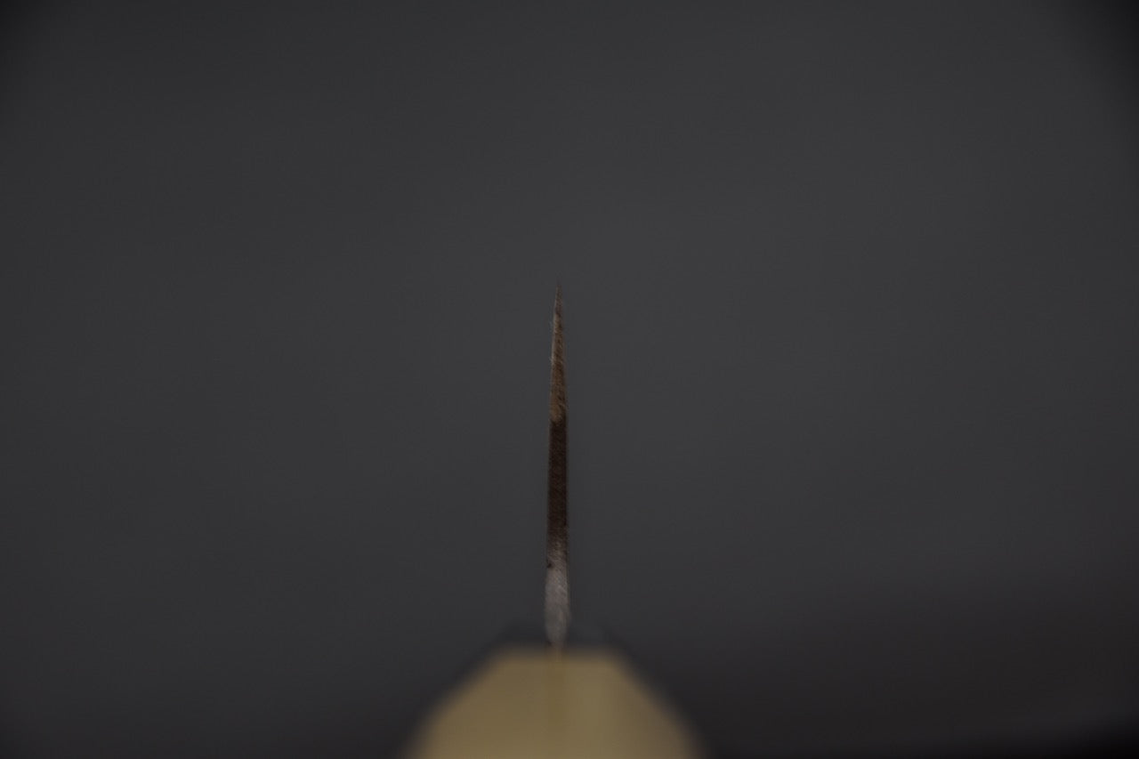 Vue de face du couteau japonais montrant l’épaisseur de la lame au dos.
