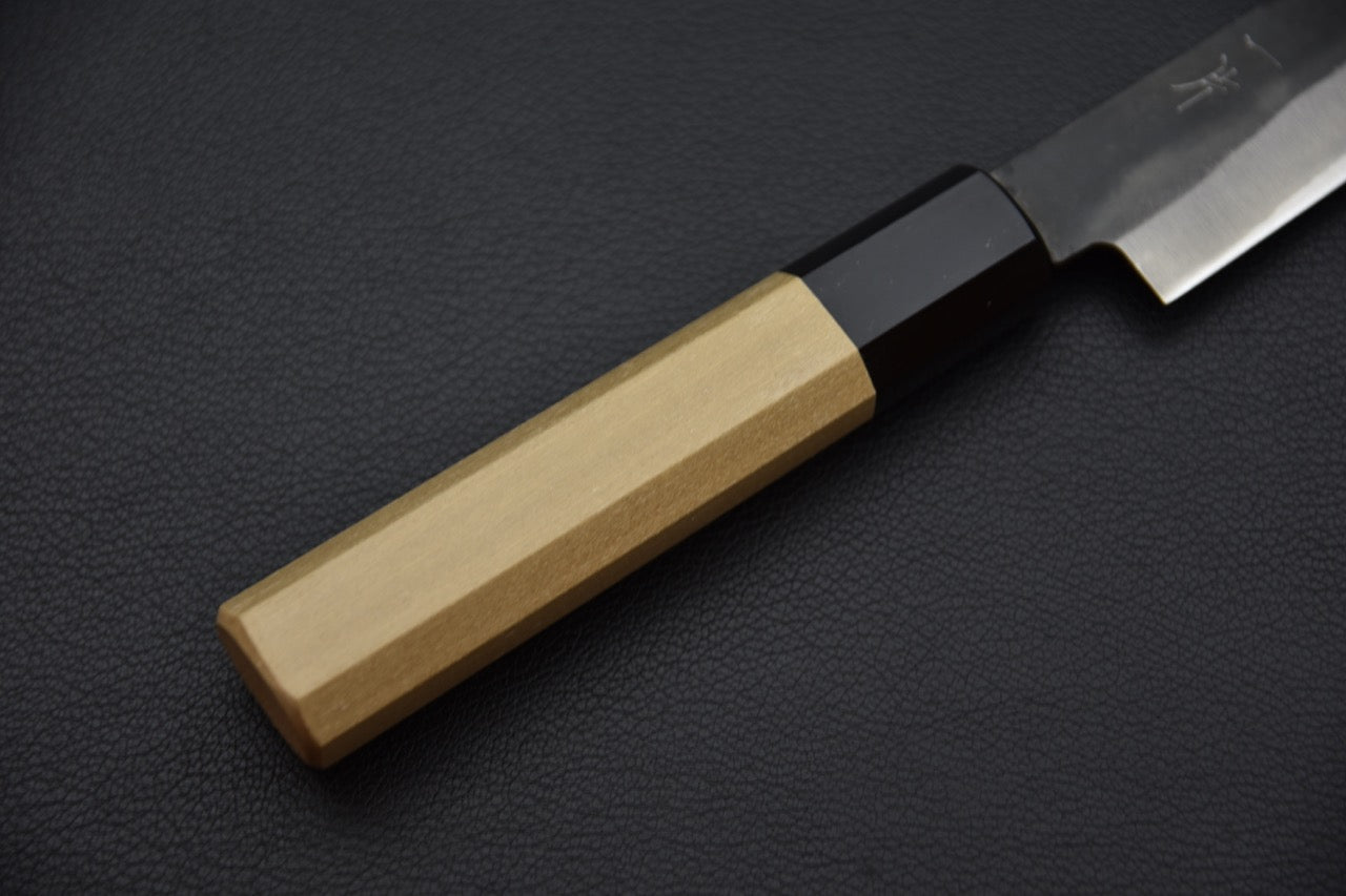 Manche octogonal en bois de ho et buffle d’un couteau japonais Petty élégant et traditionnel.