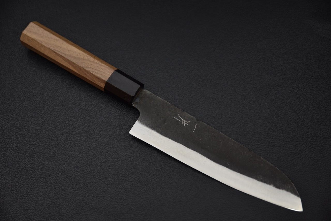 Couteau japonais santoku finition kurouchi présentant lame brute et tranchant affûté.
