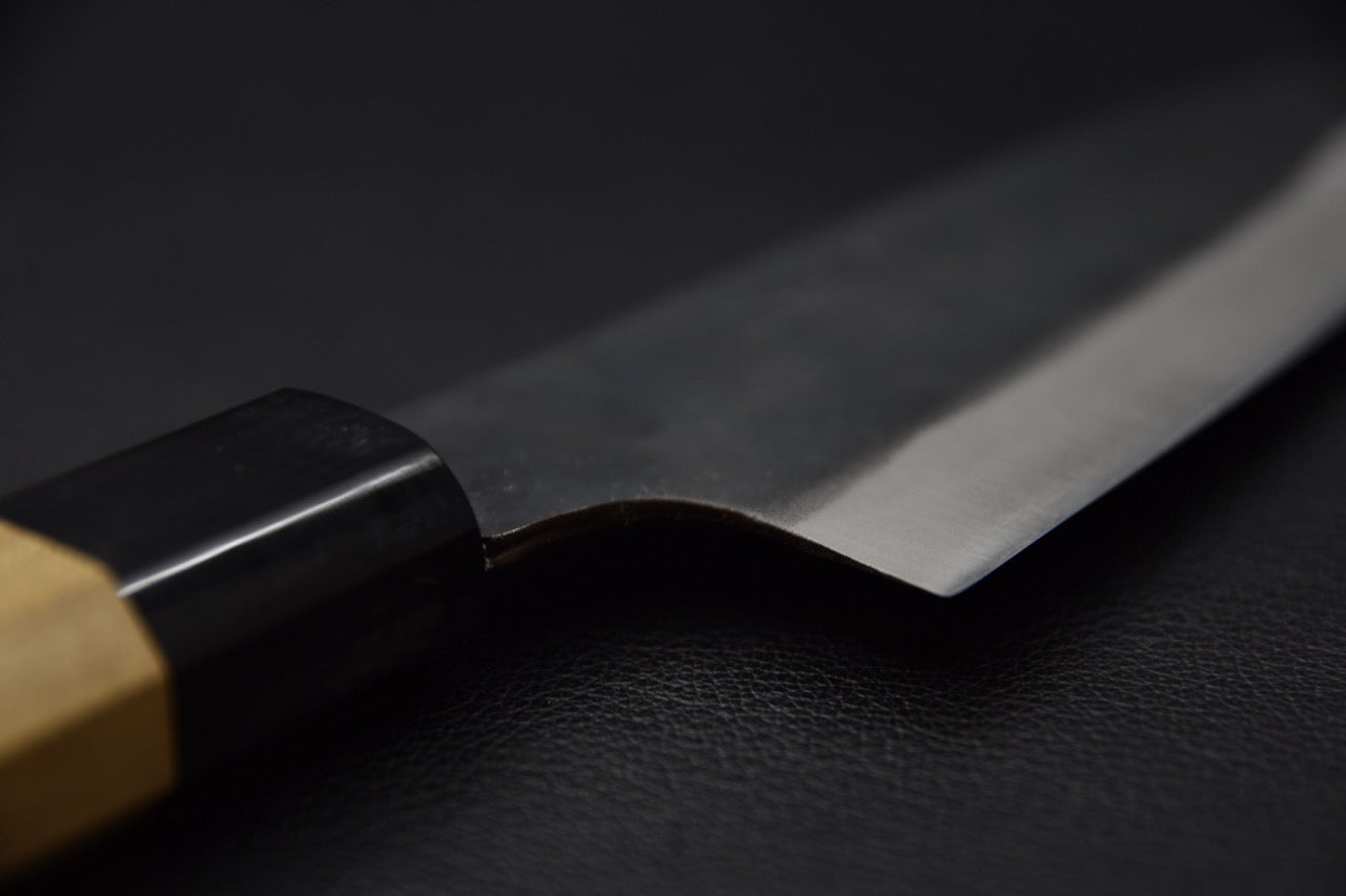 "Vue de la pointe du couteau japonais Hitohira Hizen Kurouchi Gyuto 155 mm montrant l’émoulage et la finesse de la lame."