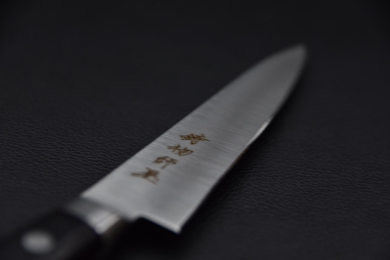 Gros plan sur la lame du couteau japonais Hitohira Imojiya KF avec gravure japonaise