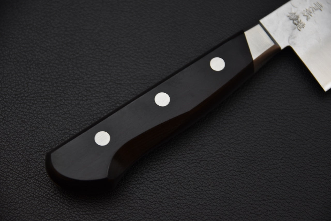 Vue rapprochée du fil du couteau japonais montrant la finesse du tranchant.