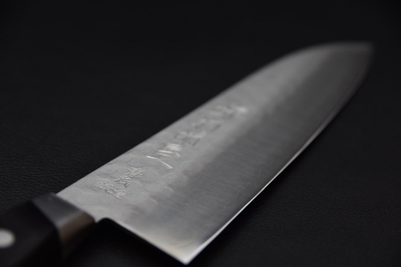 Détail du martelage Tsuchime sur la lame du couteau japonais Hitohira Imojiya Kuma Santoku 180mm.