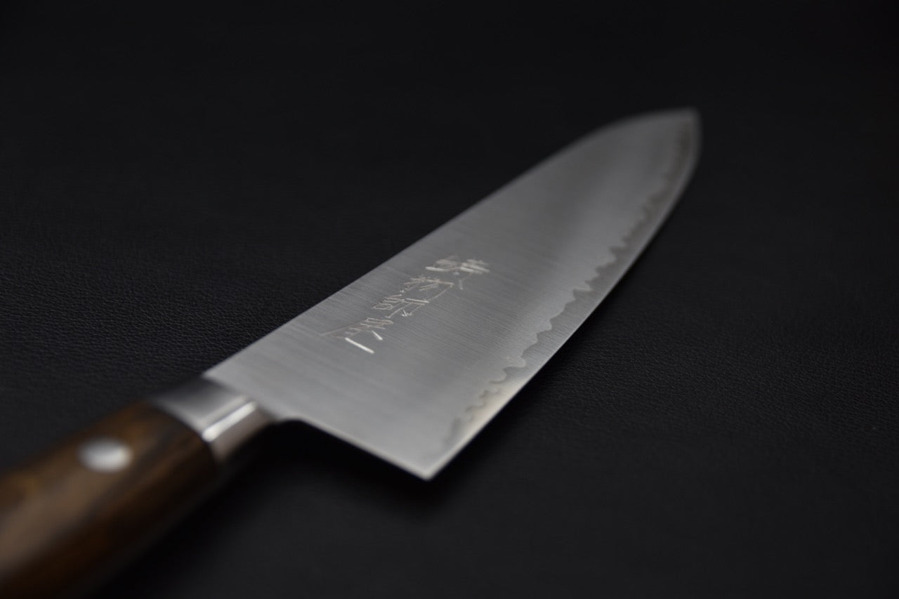 Couteau japonais vue tranchant tranche fine et talon travaillé sur fond sombre