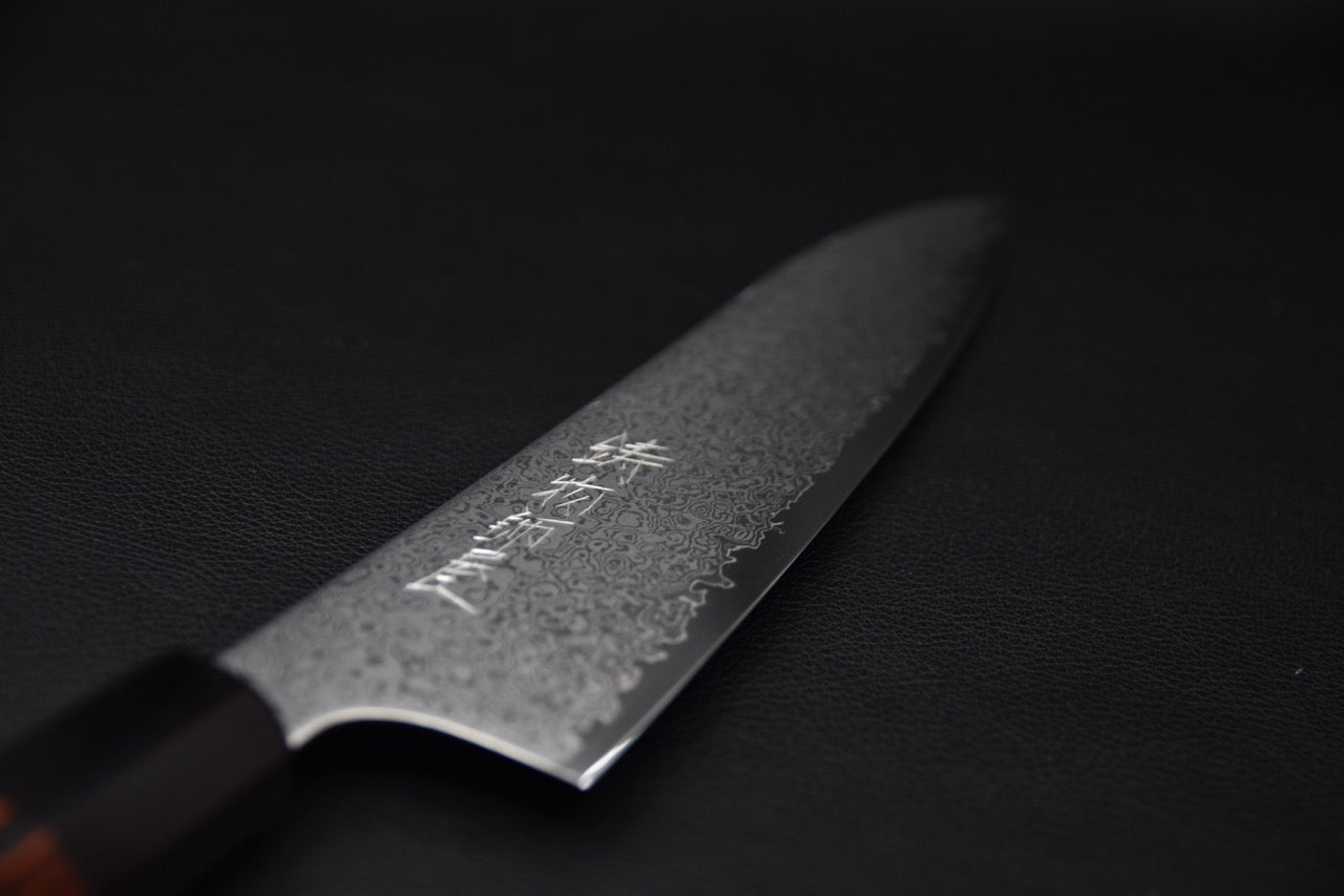 Détail lame damassée du couteau japonais avec marque gravée.