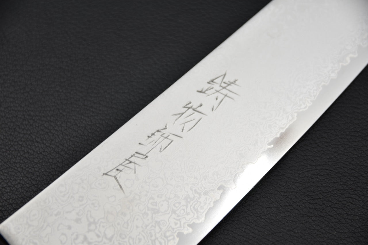 Gros plan sur motif damas et gravure du couteau japonais gyuto.