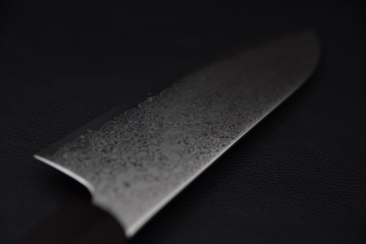 Gros plan sur la finition damassée de la lame
