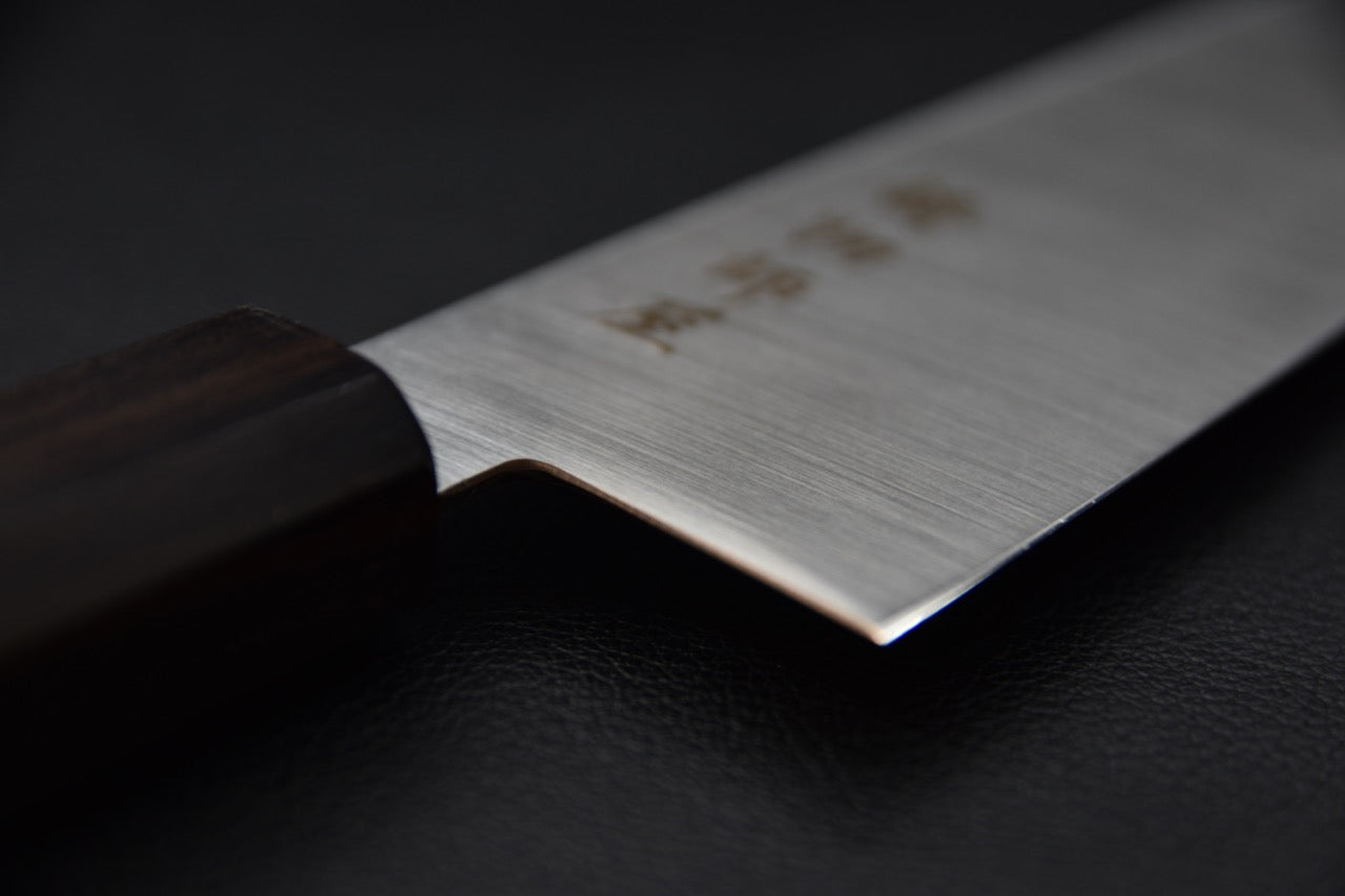 couteau japonais santoku avec gravure noire sur lame brillante et manche sobre.

