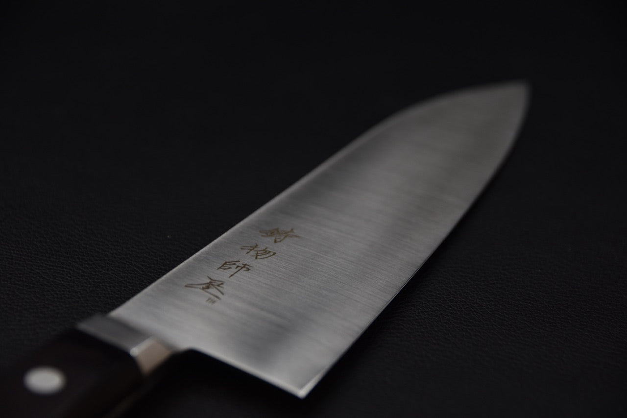 Détail de la lame satinée du couteau japonais Santoku Hitohira Imojiya TH Stainless avec kanji gravés.