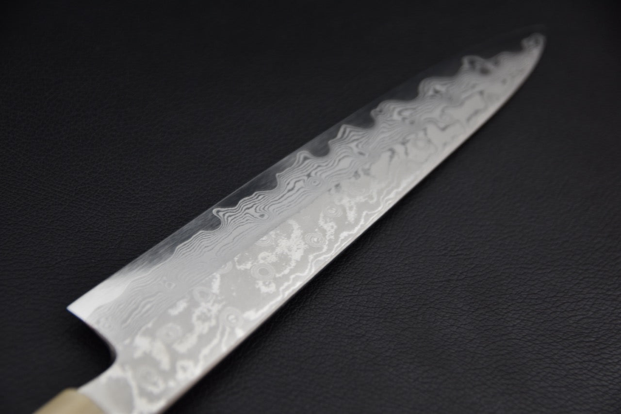 Couteau japonais gyuhiki en VG-10, détail du damas sur la longueur de la lame en perspective.