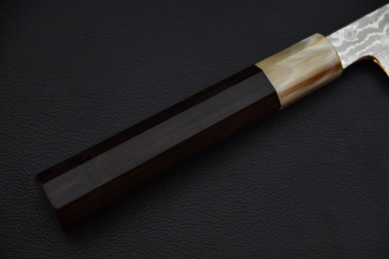 Couteau japonais avec manche wa en ébène, gros plan sur le manche octogonal et la virole en corne claire.