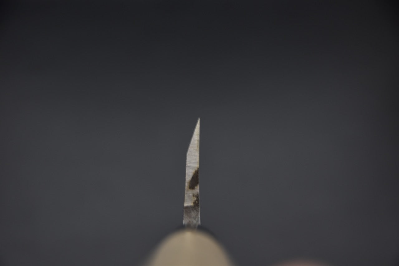 Vue en contre-plongée de la pointe aiguisée du couteau Deba